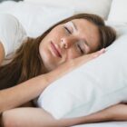 Žena mirno spava na boku, naslonjena na udoban jastuk koji podržava vrat i glavu