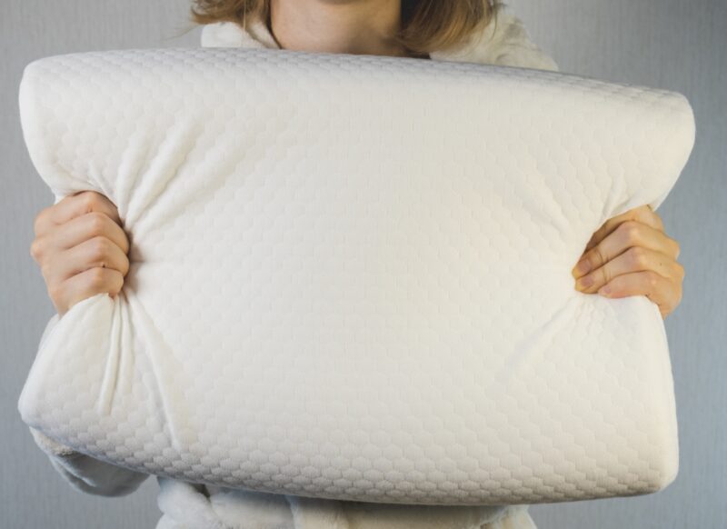 prikaz devojke koja drži jastuk od memorijske pene u svojim rukama