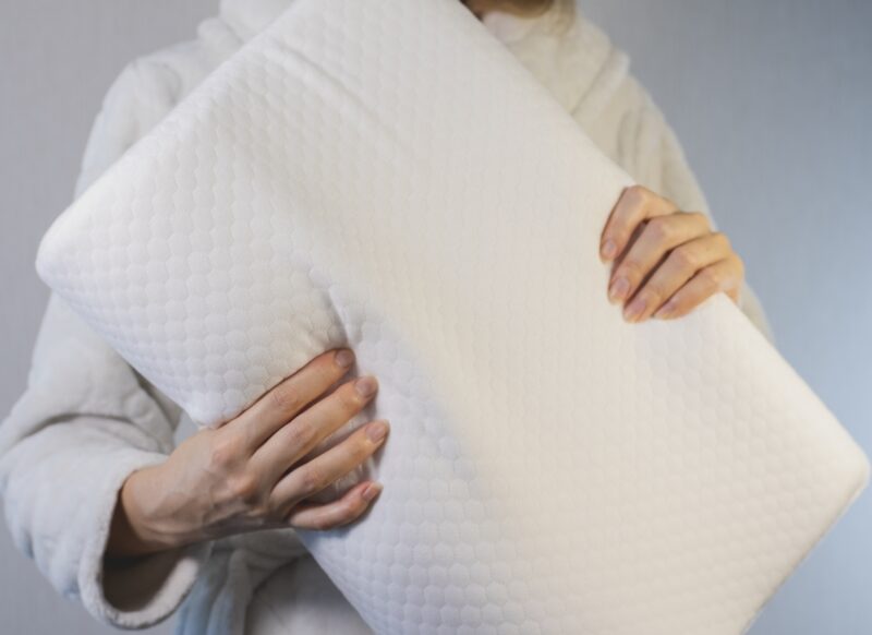 prikaz ženske osobe koja drži jastuk od memorijske pene u ruci